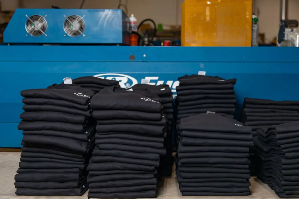 Bulk screen printing services for distributors Screen printed t-shirts stacked and ready for wholesale shipment